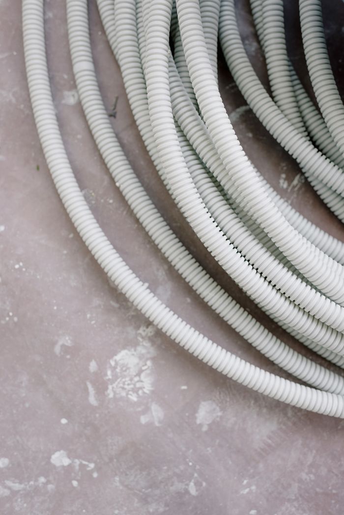 From above of plastic wires on dirty floor during renovation in room at home